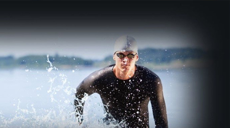 Open-water swimmer emerging from a lake